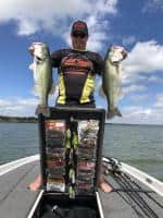 Tournament winning angler holding large bass caught while using Easy View Tackle System